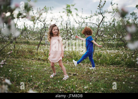 Kleinen Jungen und Mädchen im blühenden Garten Stockfoto