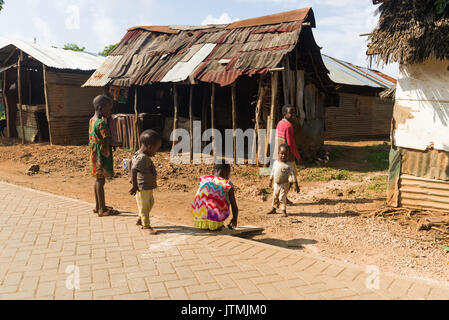 Wellblech und Holz- shack Gebäude mit kleinen Kindern spielen im Freien, Kenia Stockfoto