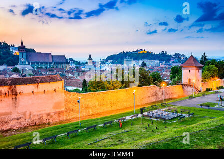 Brasov, Rumänien - Twilight Bild mit mittelalterlichen ummauerten Befestigungen, Schwarze Kirche und die Zitadelle in Siebenbürgen. Stockfoto