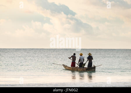 Fischer Kopf heraus in kleinen Dhow Holzboot im frühen Morgenlicht, Diani, Kenia Stockfoto