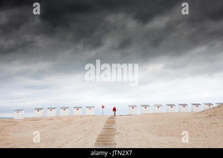 Beach Cabins unter einem stürmischen Himmel am Strand in Oostduinkerke, Belgien Stockfoto