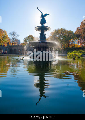 Bethesda fountain im Central Park, New York City gegen die Sonne mit Engel Statue im Wasser widerspiegelt Stockfoto