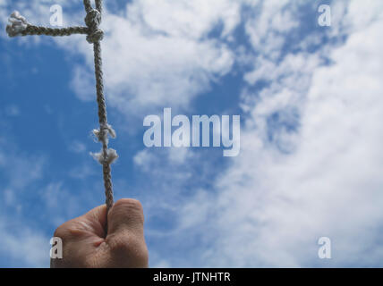 Der Menschen Hand an dem Seil ist es fast unter dem Himmel nicht vorhanden. Stockfoto