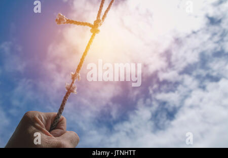 Der Menschen Hand an dem Seil ist es fast unter dem Himmel nicht vorhanden. Stockfoto