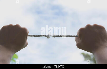 Der Menschen Hand an dem Seil ist es fast unter dem Himmel nicht vorhanden. Stockfoto