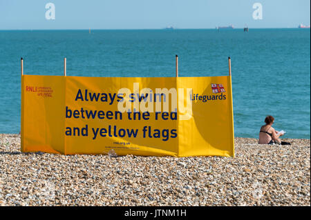 RNLI Rettungsschwimmer Windschutz anmelden Southsea Strand in Hampshire. Schwimmen betweeneo rot-gelben Flaggen. Stockfoto