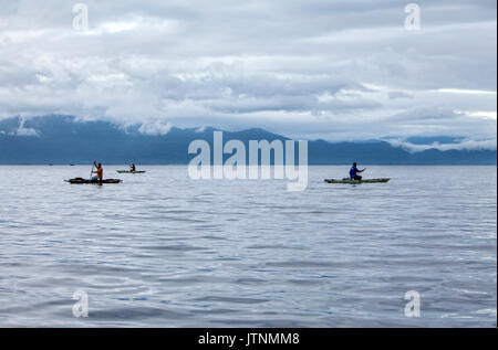 Am frühen Morgen Fischer am Outrigger Kanu in der alotau Bay. Alotau ist die Hauptstadt der Milne Bay Provinz, Provinz von Papua-Neuguinea. Die Stadt befindet sich in der Gegend, in der die Invasion der japanischen Armee ihre erste Niederlage in den pazifischen Krieg 1942 erlitt, vor dem Kokoda Track Schlacht befindet. Ein Memorial Park an der alten Schlacht site erinnert an das Ereignis. Alotau wurde die Hauptstadt der Provinz im Jahr 1969, nachdem Sie es aus Samarai verschoben wurde. Alotau ist das Tor zu den Milne Bay Provinz enthält einige der abgelegensten Insel der Welt. Für renommierte Stockfoto