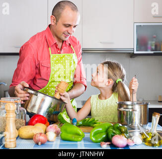 Lächelnder Mann mit süßen kleinen Tochter zusammen kochen in der Küche zu Hause. Stockfoto