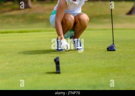 Junge Frau Inverkehrbringen Golfball auf T-Stück Stockfoto