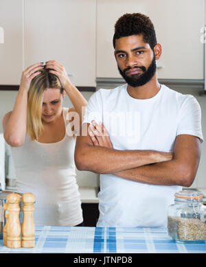 Unglücklich europäischen interracial Familie Paar mit ernsten Gesichtern in der Küche streiten. Im Mittelpunkt der Mensch Stockfoto