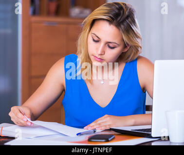 Müde Mitarbeiterin Schreibarbeit zu tun im Büro Stockfoto