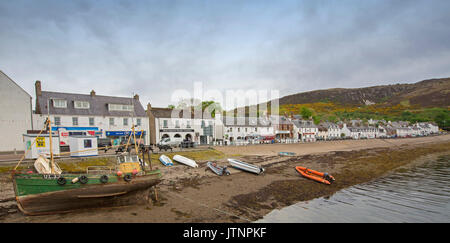 Panoramische Ansicht des Schottischen Küstenstadt Ullapool mit weiß gestrichenen Geschäfte und Häuser und Boote im Hafen neben Main Street Stockfoto