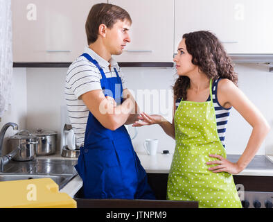 Unprofessionell Klempner, wütende junge Frau für Bestechungen im Innenbereich Stockfoto