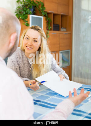 Glücklich lächelnde Paar Diskussion über Details der Verbindung Regelung im Innenbereich Stockfoto