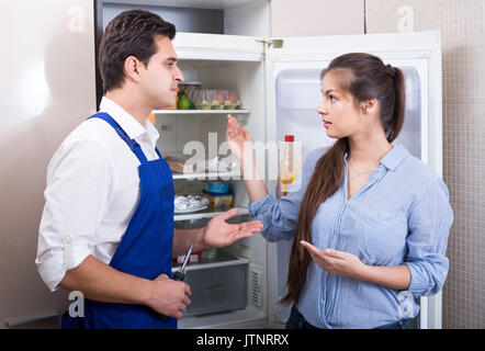 Spanische Soldaten bitten Hausfrau der technischen Probleme, die mit einem Kühlschrank zu Hause Stockfoto