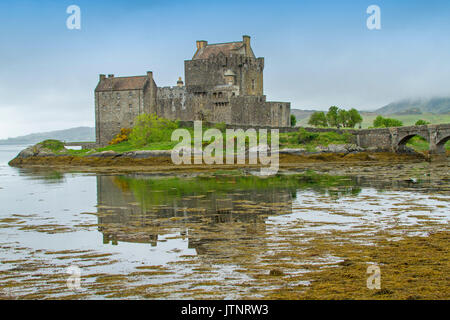 Aussicht auf das spektakuläre Eilean Donan Castle in Wasser von flachen Loch gegen den blauen Himmel in Schottland wider Stockfoto