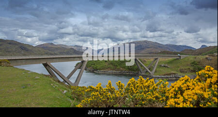 Panoramablick auf einzigartige Kylescu Brücke über einem Loch in eine Landschaft, die von Bergen, blauen Wasser dominiert, und goldenen Blumen der Ginster in Schottland Stockfoto