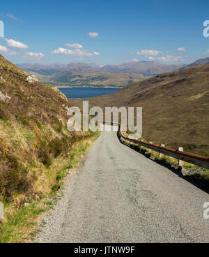 Spektakuläre Aussicht entlang der Straße nach Kylerhea auf der Isle of Skye, mit Bergen von Festland Schottland im Abstand über die blauen Wasser des Ozeans unter blauen Himmel Stockfoto