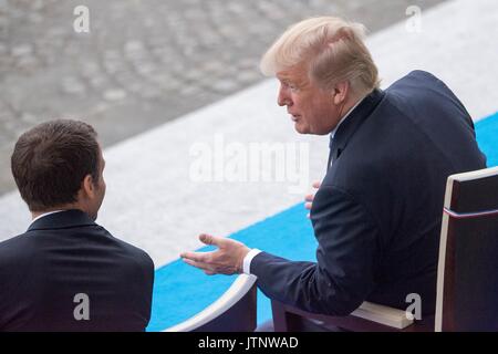 Der französische Präsident Emmanuel Längestrich Chats mit US-Präsident Donald Trump während der Bastille Tag militärische Parade entlang der Champs-Elysees Juli 14, 2017 in Paris, Frankreich. Die erste Familie in Paris wird das 100-jährige Jubiläum der Eintritt der USA in den Ersten Weltkrieg und Bastille besuchen Tag feiern zu gedenken. Stockfoto