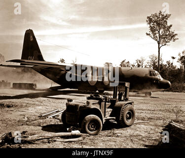 Eine Luftwaffe C-130 B Hercules-transportflugzeuge, das arbeitstier von taktischer Lufttransport in Vietnam, leert Paletten der Ladung an einem entfernten Landebahn. Stockfoto