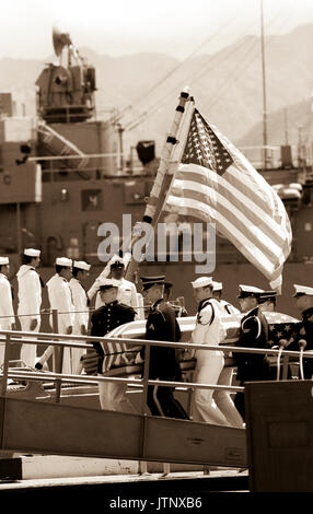 Eine gemeinsame Dienstleistungen Schatulle Team trägt die Fahne - drapierte Schatulle der Unbekannte Soldat der Vietnam ära auf der Fregatte USS BREWTON (FF 1086), bei Abschluss eines Kranzniederlegung. Der Sarg wird zu Kalifornien transportiert werden und dann auf dem Arlington National Cemetery übertragen zu beerdigen, am Grab des Unbekannten. Stockfoto