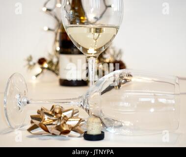 Zwei Weingläser mit Weißwein, Flasche und Weihnachtsdekor Stockfoto
