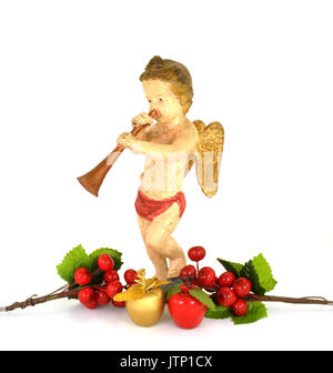 Weihnachten Cherub - antike Puppe von Äpfeln & Stechpalme Beeren auf einem weißen Hintergrund umgeben. Stockfoto