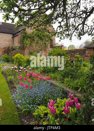 Unter dem Apfelbaum am Chenies Manor Garden, Buckinghamshire Blick in die restaurierte Pavillon im Frühling mit Tulpen. Stockfoto