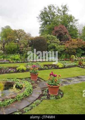 Hochformat von chenies Manor Sunken Garden suchen South West im Frühling mit Tulpen, Zierteich, Torbögen und Ebenen der formalen Einpflanzen. Stockfoto