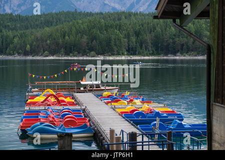 Bunte Tretboote vertäut an der Pier am Eibsee, Bayern, Deutschland Stockfoto