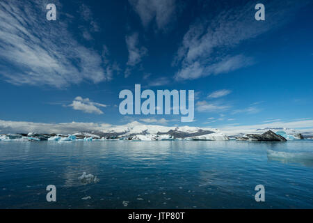 Island - Blauer Himmel mit Sonne über schmelzendes Eis der Gletscher See Stockfoto