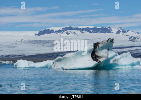 Island - Beeindruckende Eisberg treiben im Gletschersee mit Gletscher im Hintergrund Stockfoto