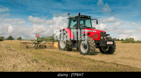 Großbritannien Landwirtschaft - Traktor und Heu rechen an Arbeit August 2017 Stockfoto