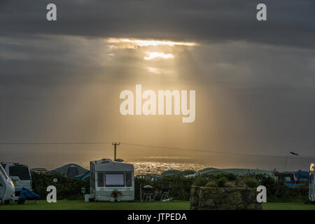 Sonnenstrahlen brechen durch Cloud und Beleuchtung bis zum Meer neben einem Campingplatz in Sennen (in der Nähe von Lands End), Penzance, Corwall, England, UK. Stockfoto