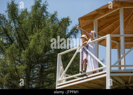 Tochter und Mutter steht in einer Nische im Garten. Stockfoto