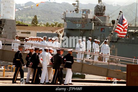 Eine gemeinsame Dienstleistungen Schatulle Team trägt die Fahne - drapierte Schatulle der Unbekannte Soldat der Vietnam ära auf der Fregatte USS BREWTON (FF 1086), bei Abschluss eines Kranzniederlegung. Der Sarg wird zu Kalifornien transportiert werden und dann auf dem Arlington National Cemetery übertragen zu beerdigen, am Grab des Unbekannten. Stockfoto