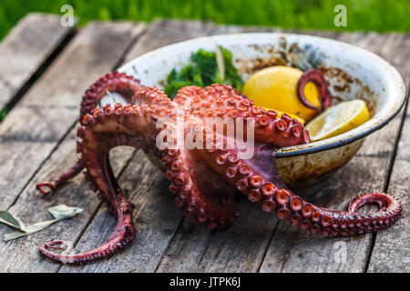 Big gekochten Tintenfisch mit Zitrone und Petersilie, rustikalen Stil Stockfoto