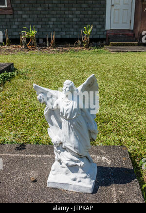 Eine Statue von einem Engel sitzt auf einem Friedhof auf Maui, Hawaii. Stockfoto