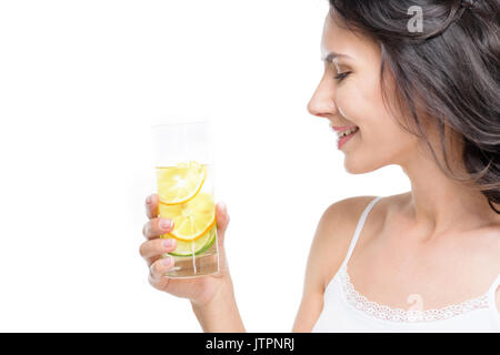 Seitenansicht der Frau hält Glas Wasser isoliert auf weißem Stockfoto