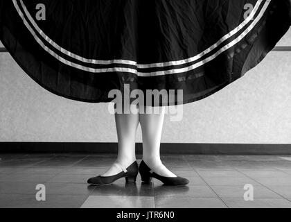 Schwarz/weiße Version des Charakters Balletttänzer in der ersten Stellung ihr Rock Holding Stockfoto