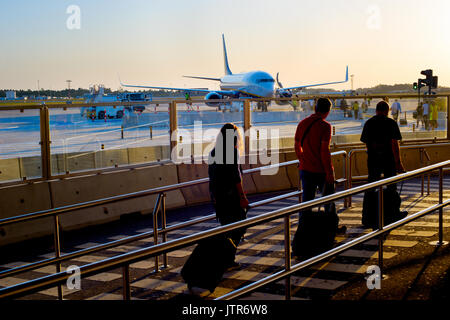 Die Fluggäste Flugzeug am Flughafen bei Sonnenuntergang Stockfoto