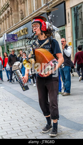 One Man Band Straßenmusik in den belebten Einkaufsstraßen von Liverpool können Sie über eine Reihe von Musikinstrumenten, Stockfoto