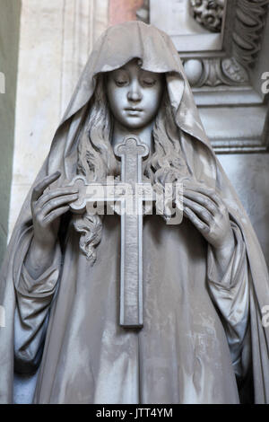 Frau mit Trauer das Kreuz auf dem Marmor Begräbnis Monument der Poggi Familie von italienischen Bildhauer Federico Fabiani an der Staglieno monumentale Friedhof (Cimitero monumentale di Staglieno in Genua, Ligurien, Italien dargestellt. Inschrift im Gespräch mit dem Fidesdienst am Kreuz bedeutet: Ich verlasse mich auf Sie. Stockfoto