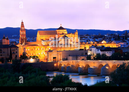 Römische Brücke und Fluss Guadalquivir leuchtet in der Dämmerung, Große Moschee in Cordoba, Spanien Stockfoto