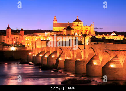 Römische Brücke und Fluss Guadalquivir leuchtet in der Dämmerung, Große Moschee in Cordoba, Spanien Stockfoto
