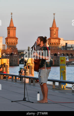 Berlin, Deutschland. 09 Aug, 2017. Straßenmusiker Konstanthyme spielt am frühen Abend entlang der Spree, nicht weit von der Oberbaumbrucke Brücke, Berlin, Deutschland, 09. August 2017. Foto: Paul Zinken/dpa/Alamy leben Nachrichten Stockfoto