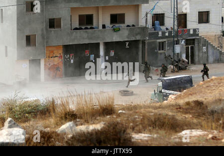 Ramallah, West Bank, Palästina. 10 Aug, 2017. Israelische Soldaten in der Nähe des Hauses einer palästinensischen Attentäter, nachdem es von israelischen Truppen im Westjordanland Dorf Deir Abu Mashal, in der Nähe von Ramallah abgerissen wurde, am 10. August 2017. Die israelischen Behörden drei Wohnungen abgerissen haben und abgeschottet ein Viertel der Palästinenser, die durchgeführten Angriffe, einem Soldaten und eine Polizistin getötet, die Armee sagte. Israel führt in regelmäßigen Abständen diese Zerstörungen, die es sagt, abschreckend, aber Menschenrechtsgruppen und Palästinenser sagen, dass sie Familien für die Handlungen der Verwandten (Credit bestrafen Stockfoto