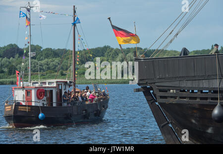 Rostock, Deutschland. 10 Aug, 2017. Historische Schiffe sind die Touristen, die nach der Eröffnung des 27. Hanse Sail im Stadthafen in Rostock, Deutschland, 10. August 2017. 190 traditionelle Segelschiffe haben für dieses Jahr registriert worden. Foto: Stefan Sauer/dpa/Alamy leben Nachrichten Stockfoto