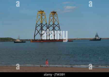 Fluss Tyne, South Shields, Großbritannien, 10. August 2017. Windkraftanlagen Grundlagen, an der Mündung des Flusses Tyne auf dem Weg in die Beatrice Offshore Windpark in den Moray Firth geschleppt. Aufgrund ihrer Höhe National Grid hatte auf die Höhe der Stromkabel über den Fluss Tyne heben trotz der Pylone, zwei der höchsten in Großbritannien, nur durch Sätze überspannt den Fluss Themse in der Nähe von London und den Fluss Severn in Bristol übertroffen. Credit: Colin Edwards/Alamy Leben Nachrichten. Stockfoto