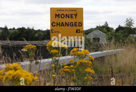 Newry, Nordirland. 10. August 2017. Ein Zeichen für den Umtausch von Währungen Euro und Pfund liegt an der Grenze zwischen der Republik Irland und Nordirland außerhalb von Newry, Co unten gesehen. Eine verlassene Grenze Hütte ist im Hintergrund zu sehen. Credit: Laura Hutton/Alamy Leben Nachrichten. Stockfoto